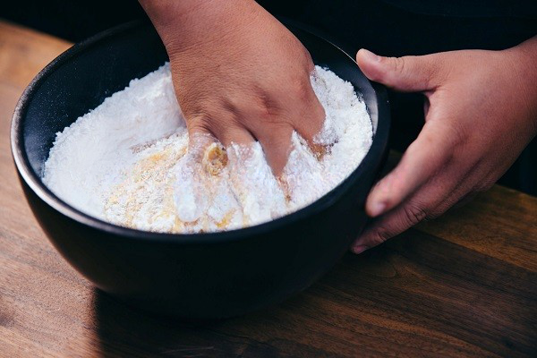 Trộn đều tay để hỗn hợp nước đường và bột quyện vào nhau.